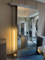 Trendy viral salon mirror for social media photos with asymmetric stainless steel frame, ideal for elegant lady influencers to take check-in selfies in a luxury salon.